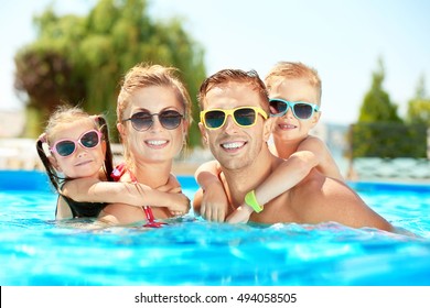 Happy Family In Swimming Pool At Water Park