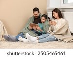 Happy family with tablet near heating radiator at home