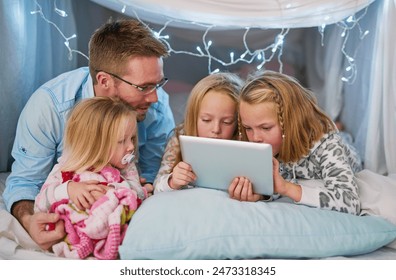 Happy, family and tablet for streaming tv, watching movies or dad telling story before bedtime. Sisters or friends and touchscreen for entertainment with film or social media in blanket fort at home - Powered by Shutterstock