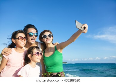 happy family taking a selfie at the beach