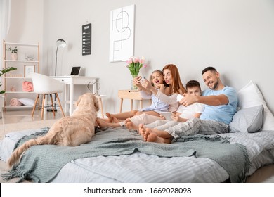 Happy Family Taking Selfie In Bedroom At Home