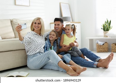 Happy family taking selfie on floor at home