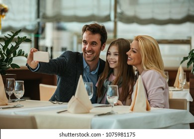 Happy Family Taking A Selfie In A Restaurant