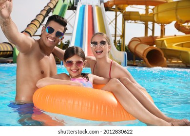 Happy family taking selfie in swimming pool at water park