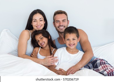 Fröhliche Familie in ihrem Schlafzimmer zu Hause