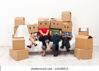 Happy Family In Their New Home Having Fun Together Sitting On The Sofa