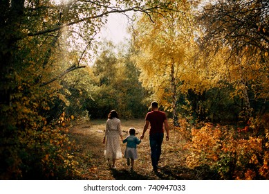 Happy family and they dauther walking in autumn park and have a nice time 
