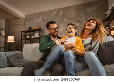 happy family of three have a fun at home tickle son and hug each other - Powered by Shutterstock