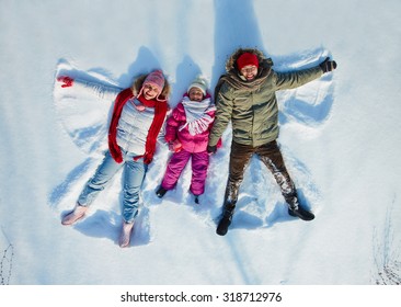 Happy family of three having fun in snowdrift