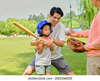 Happy Family Of Three Playing Baseball In The Park High Quality Photo