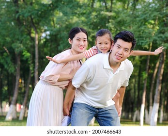 Happy family of three playing in the park high quality photo - Shutterstock ID 2007466643