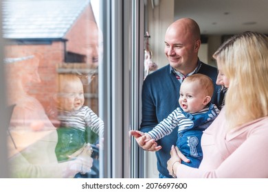 Happy family of three smiling and looking out of the window - Happy little boy with mother and father enjoying time together and having fun - Lifestyle and family concepts