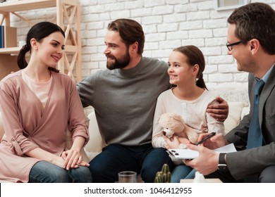 Happy family of three talking with psychologist. Family psychotherapy concept. Visit to family psychologist. Psychological help for family.