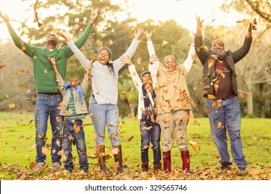 Happy family throwing leaves around in parkland - Powered by Shutterstock