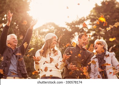 Happy family throwing leaves around on an autumns day