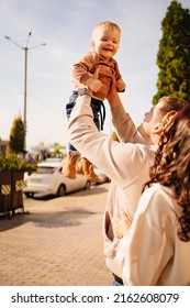 a happy family throws up a young son on a walk. happy parenthood and childhood. fashionable and beautiful clothes for children and adults.  - Shutterstock ID 2162608079