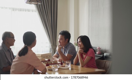 Happy Family Time And Relationship, Asian Big Family Having Small Party Together At Home. Pan Shot Of Elder Couple With Son And Daughter Talking With Fun And Smile Having Dinner On Dining Table.