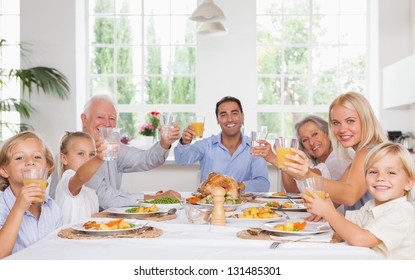 Happy Family Toasting Around The Table At Thanksgiving Dinner