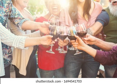 Happy Family Toasting With Red Wine Glasses At Dinner Outdoor - People Having Fun Cheering And Drinking While Dining Together - Food And Beverage Weekend Lifestyle Activities 