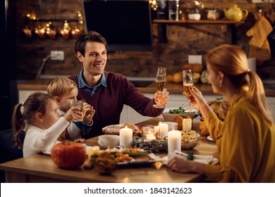 Happy family toasting while having Thanksgiving dinner at dining table. Focus is on father.  - Powered by Shutterstock