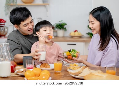 happy family together. Asian parent eating breakfast with little son in the kitchen. - Shutterstock ID 2062972538