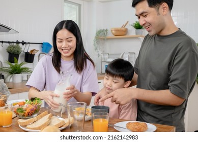 happy family together. Asian parent eating breakfast with little son in the kitchen. - Powered by Shutterstock