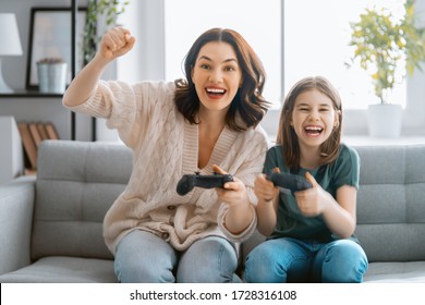 Happy Family Together. Mother And Her Child Girl Playing Video Games. People Having Fun At Home.