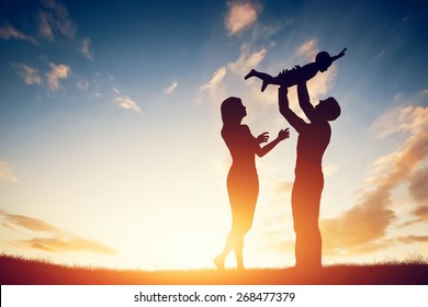 Happy family together, parents with their little child at sunset. Father raising baby up in the air. - Powered by Shutterstock