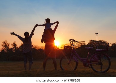 Happy family together, parents with their little child at sunset. Father raising baby up in the air. - Shutterstock ID 649789168