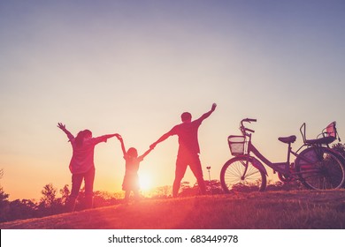 Happy family together, parents with their little child at sunset. Father raising baby up in the air. - Shutterstock ID 683449978