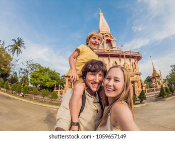 A Happy Family Of Tourists On The Background Of Wat Chalong In Thailand. Traveling With Children Concept