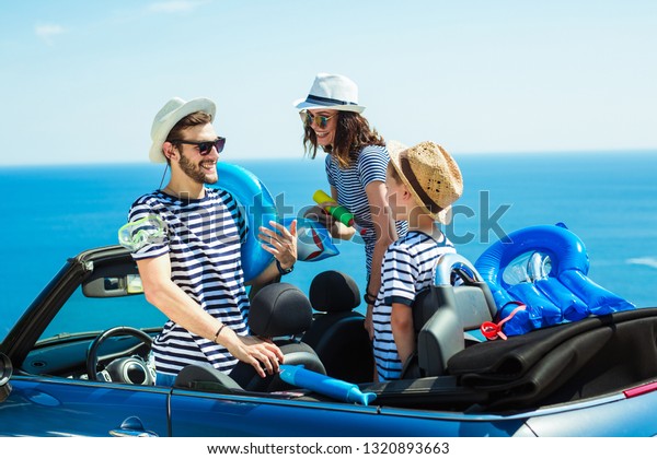 Happy family travel by car to the
sea. People having fun in cabriolet. Summer vacation
concept