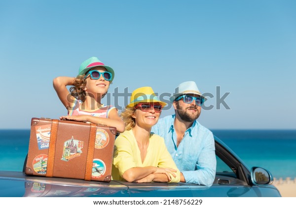 Happy\
family travel by car at the sea. Mother, father and daughter having\
fun in blue cabriolet. Summer vacation\
concept