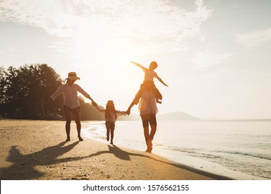Happy family travel on beach in holiday,Summer vacations. Happy family are having fun on a tropical beach in sunset. Father and mother and children playing together outdoor on beach.