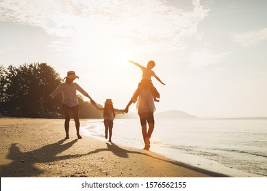 Happy Family Travel On Beach In Holiday,Summer Vacations. Happy Family Are Having Fun On A Tropical Beach In Sunset. Father And Mother And Children Playing Together Outdoor On Beach.