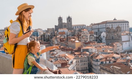 Happy family traveling. Young red-haired mother and little excited daughter looking on the Porto city, Portugal