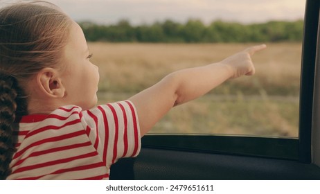 Happy family travels by car. Little girl kid enjoys family trip by car. Child, stretching his hand out of car window, laughs. Girl child looks out of car window. Child holiday emotion. Family vacation - Powered by Shutterstock