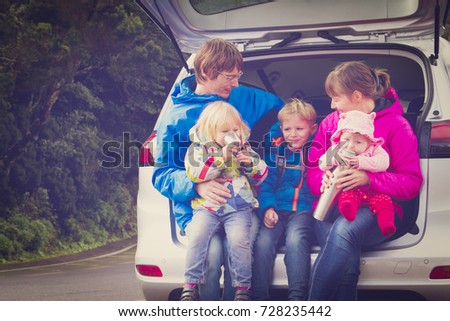 happy family with tree kids travel by car on road