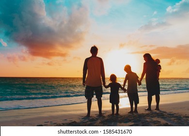 happy family with tree kids walk at sunset beach