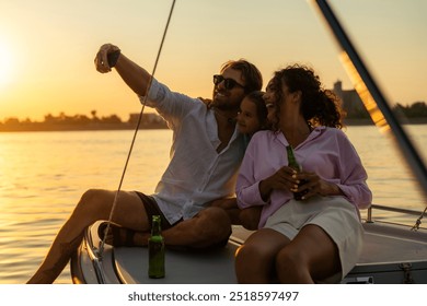 Happy family trio taking a selfie on a boat during sunset. The man is shirtless and wearing sunglasses, the woman is in a bikini top, and the child is in a pink and white outfit. - Powered by Shutterstock