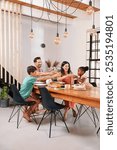 Happy family with two children (6-7, 8-9) toasting with drinks at table in dining room