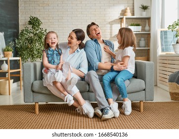Happy family! Two children daughters with mother and father. Mum, dad and girls laughing and hugging. 