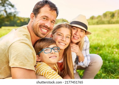 Happy Family With Two Children On A Meadow In Summer In Nature