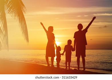happy family with two kids having fun on sunset tropical beach - Shutterstock ID 311633429