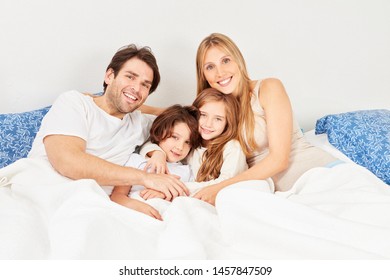 Happy Parents Two Kids Cuddling Bed Stock Photo (Edit Now) 1518170084