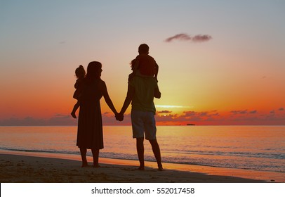 Happy Family With Two Kids On Sunset Beach