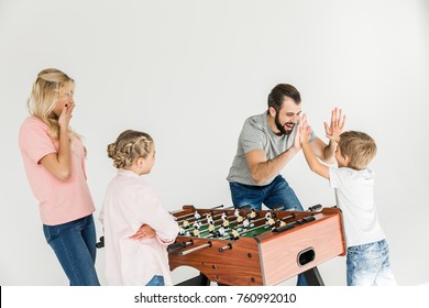 Happy Family With Two Kids Playing Foosball Isolated On White 