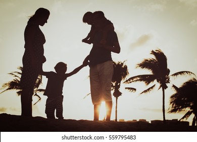 Happy Family With Two Kids At Sunset Beach