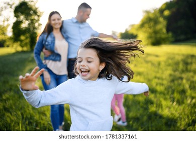 Happy Family With Two Small Daughters Having Fun Outdoors In Spring Nature.