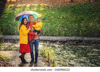 Happy Family Under The Umbrella Hide From The Rain.